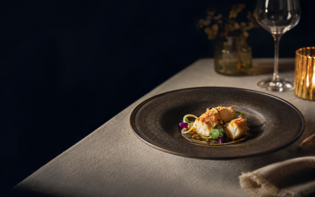 Prato de gastronomia portuguesa apresentado numa mesa elegante
